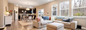 Bright, open-plan living room with neutral walls, modern furniture, and natural light