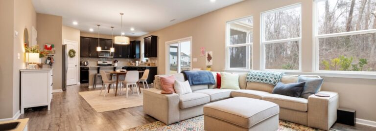 Bright, open-plan living room with neutral walls, modern furniture, and natural light