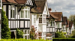 Row of traditional British countryside houses with pitched roofs and timber detailing, representing rural property checks and considerations when buying a country home.