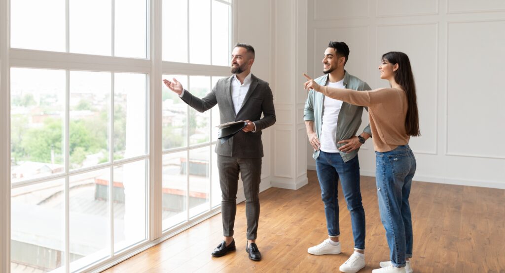 Couple viewing a countryside property with an estate agent, representing rural home maintenance considerations and challenges for country homeowners.