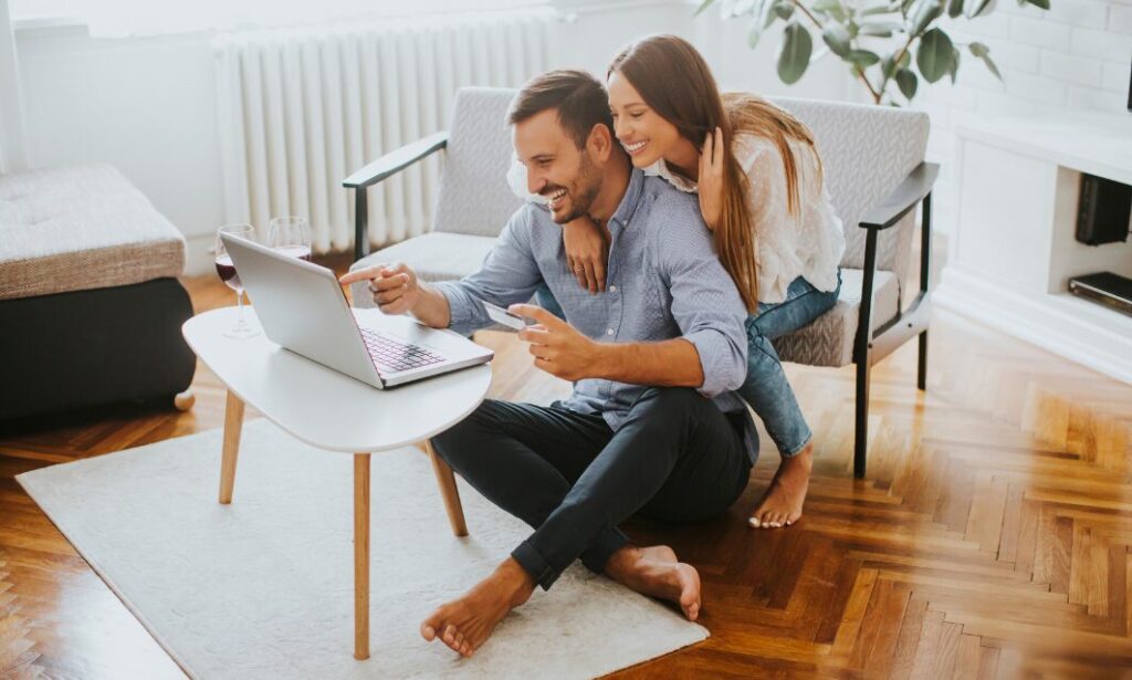 Couple researching rural property and country homes online from their living room.