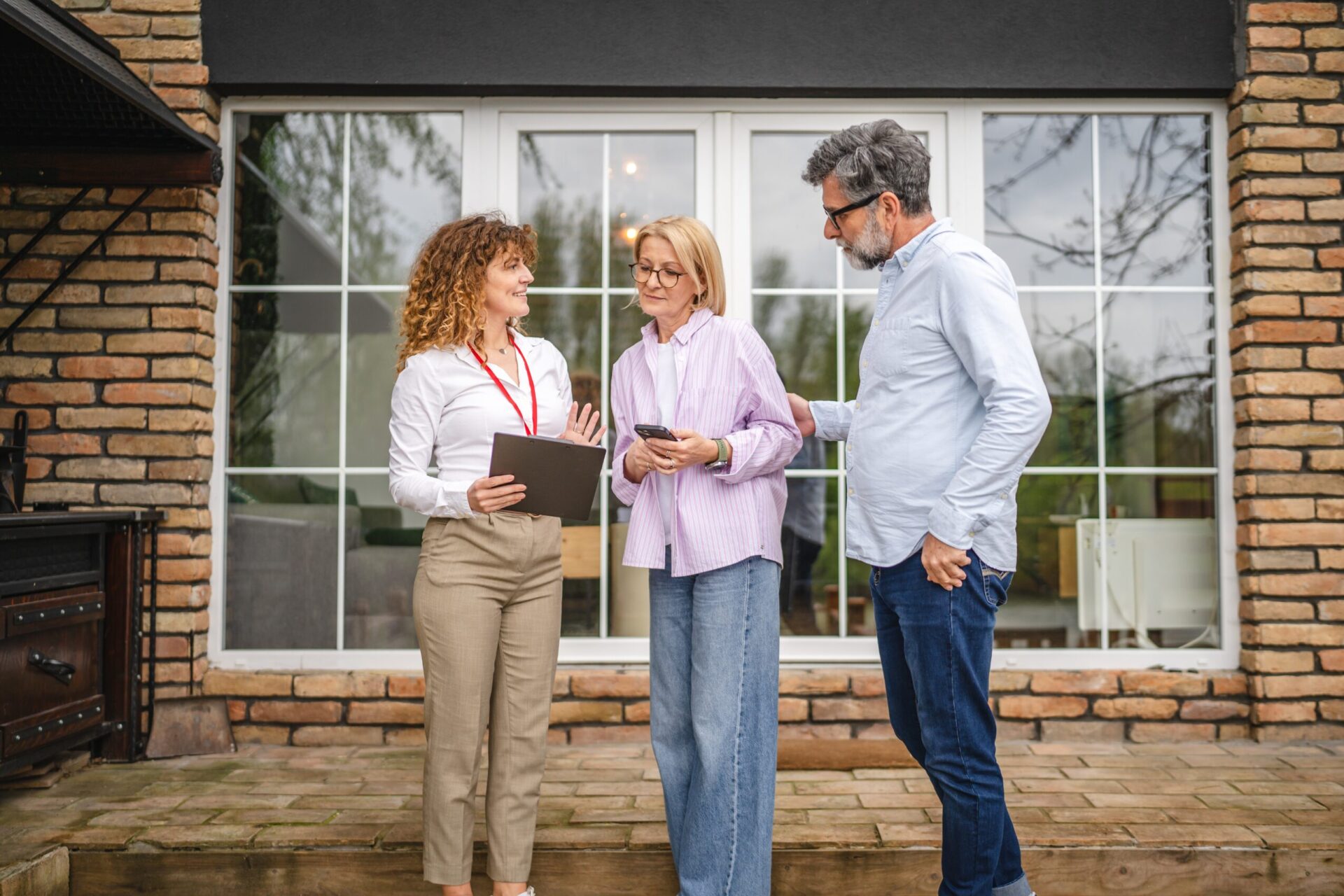 Estate agent discussing a property valuation with homeowners outside a detached house in Hitchin, reflecting renewed seller confidence following mortgage rate stability in 2026