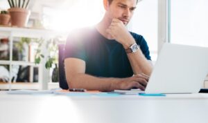 Landlord reviewing tenant application on laptop at home