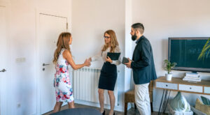 Estate agent shaking hands with a homebuyer during a property viewing in a modern living room