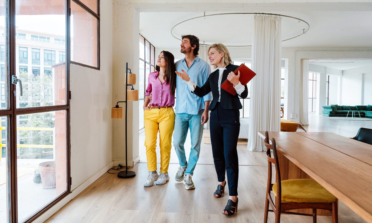 estate agent showing a modern home to a couple during property viewing