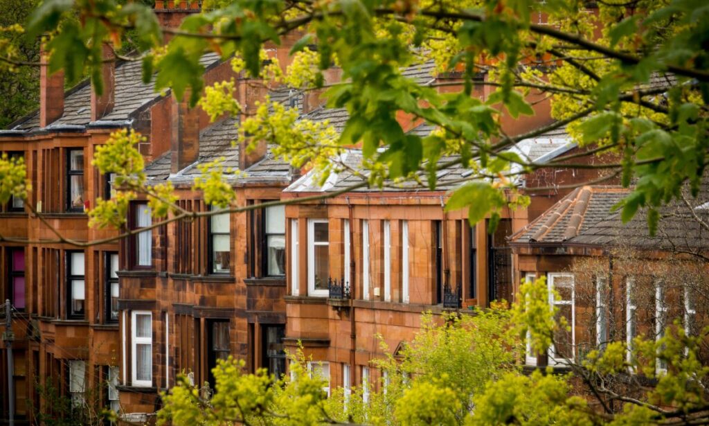 Traditional British sandstone terraced houses surrounded by green trees