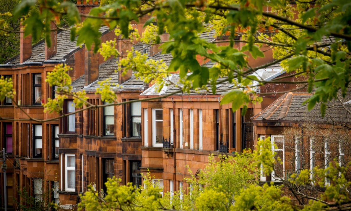 Traditional British sandstone terraced houses surrounded by green trees