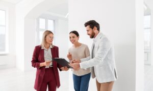 Estate agent discussing property details with clients inside a bright rental property, representing Hertfordshire rents, landlord advice and rental market guidance.