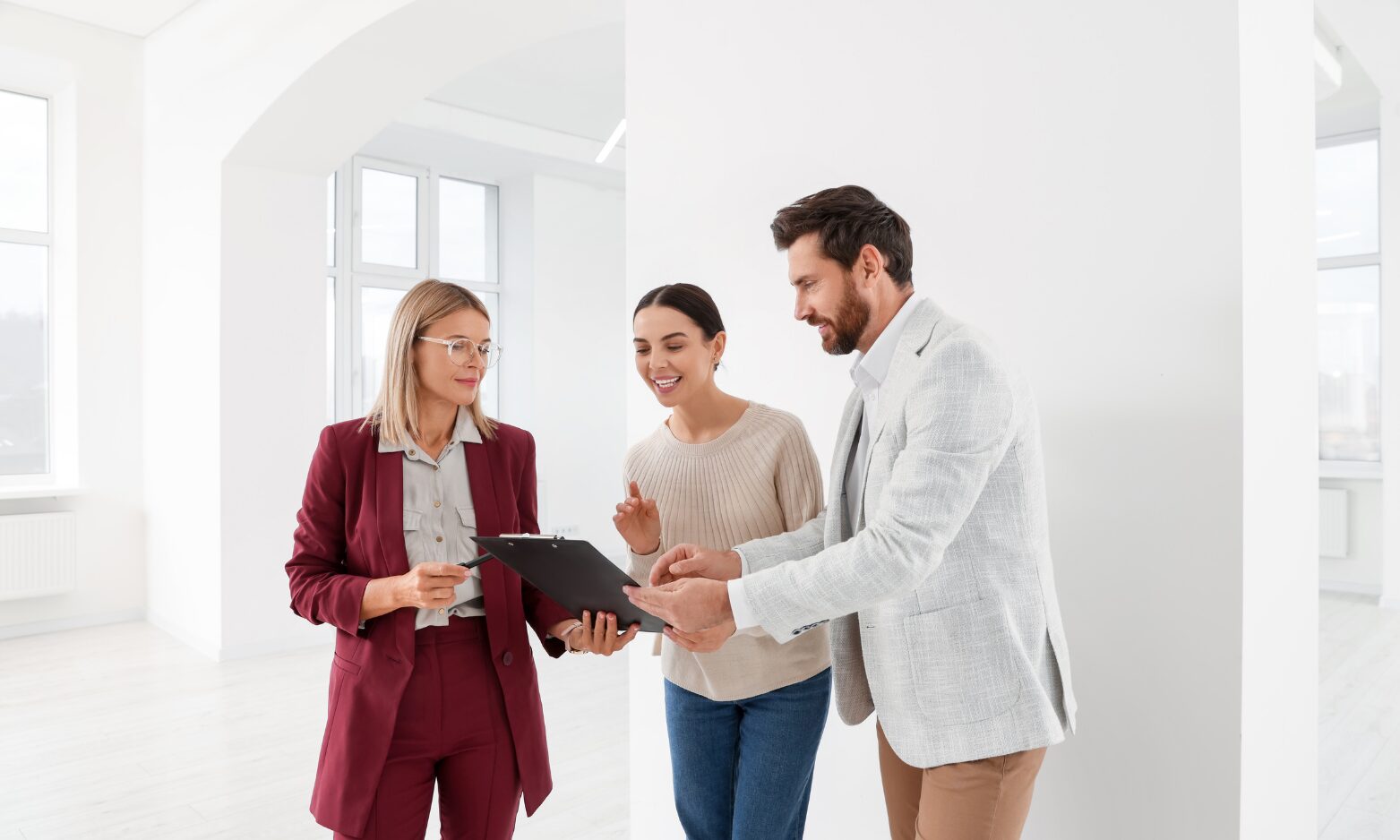 Estate agent discussing property details with clients inside a bright rental property, representing Hertfordshire rents, landlord advice and rental market guidance.
