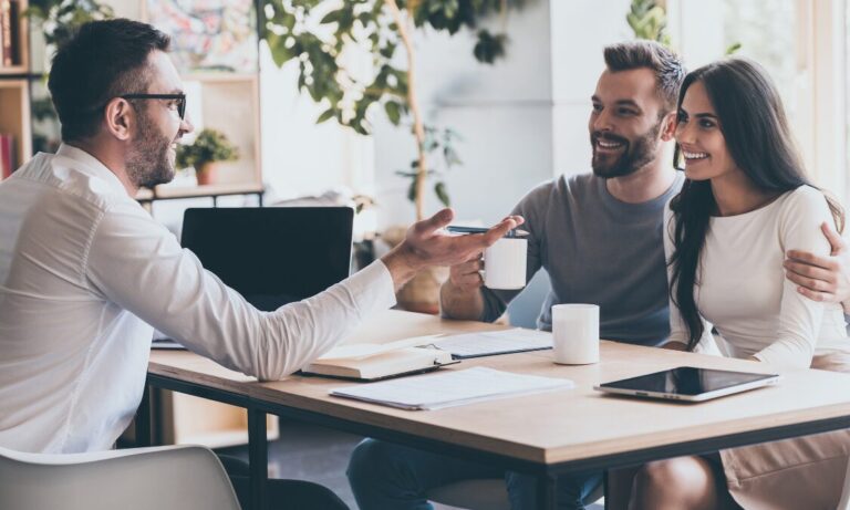 Estate agent discussing property details with buyers, representing Hitchin house price growth, local market advice and property valuation guidance.