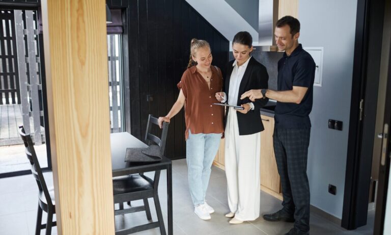 Estate agent showing a couple around a modern home, representing Letchworth Garden City house prices and buyer demand.