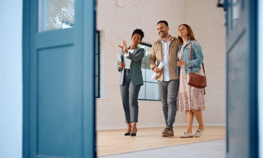 Estate agent showing buyers around a bright property, representing Hertfordshire house prices, commuter town comparisons and buyer advice.