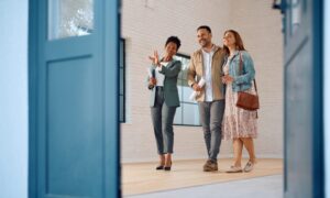 Estate agent showing buyers around a bright property, representing Hertfordshire house prices, commuter town comparisons and buyer advice.