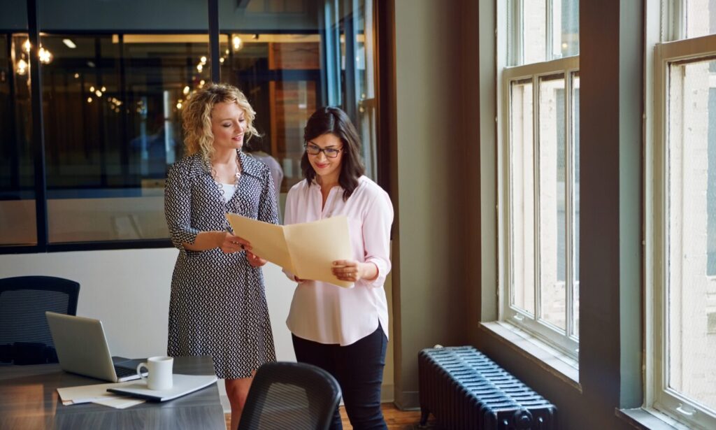 Two property professionals reviewing rental documents in an office, representing landlord compliance and property management in Hertfordshire.