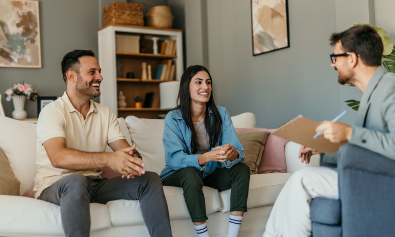 Property agent discussing rental investment with a couple in their home
