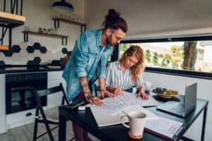 A couple reviewing house plans together at their kitchen table, representing buying a home in Baldock SG7.