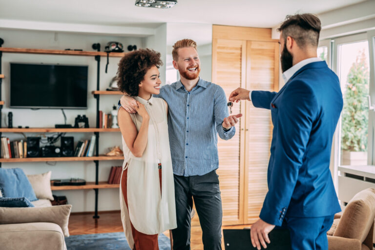 Letting agent handing property keys to tenants in a Royston home