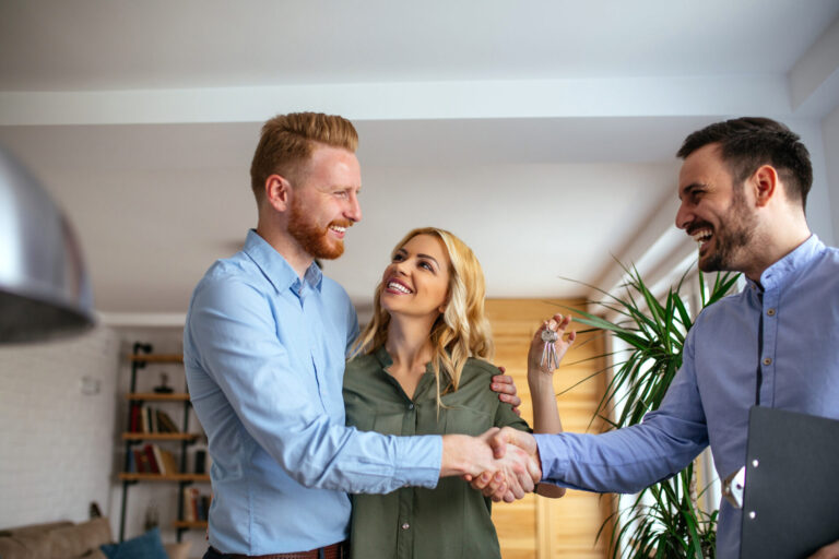 Homebuyers receiving keys from an estate agent, representing buyers and sellers navigating the Hitchin property market.