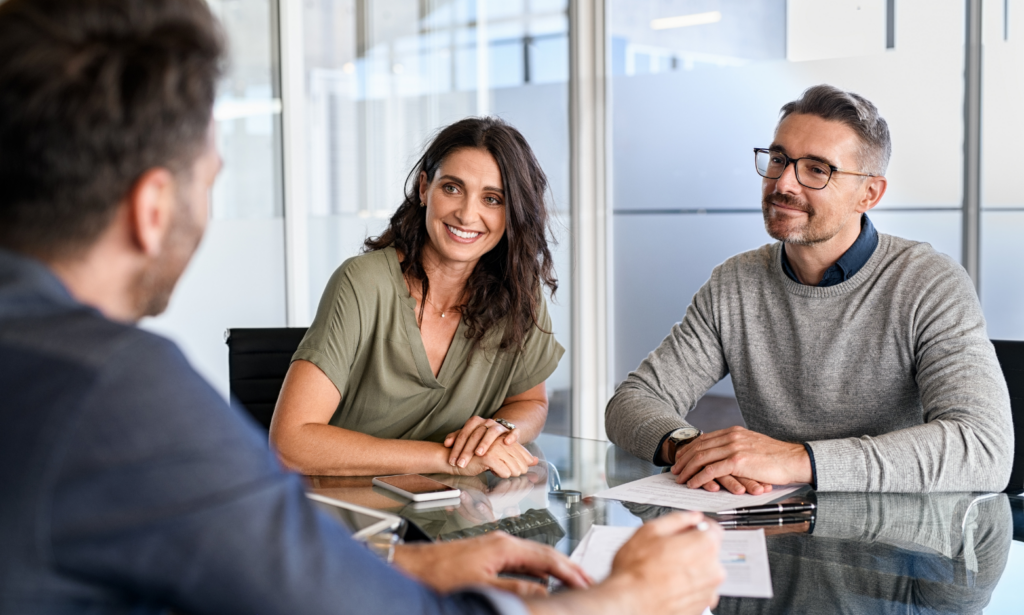 Homeowners discussing their property sale with an estate agent during a professional consultation.