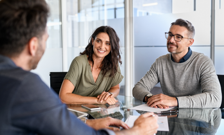 Homeowners discussing their property sale with an estate agent during a professional consultation.