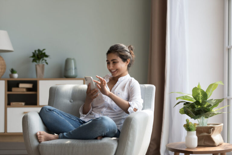 Woman using a smartphone while relaxing at home in Preston, Hitchin